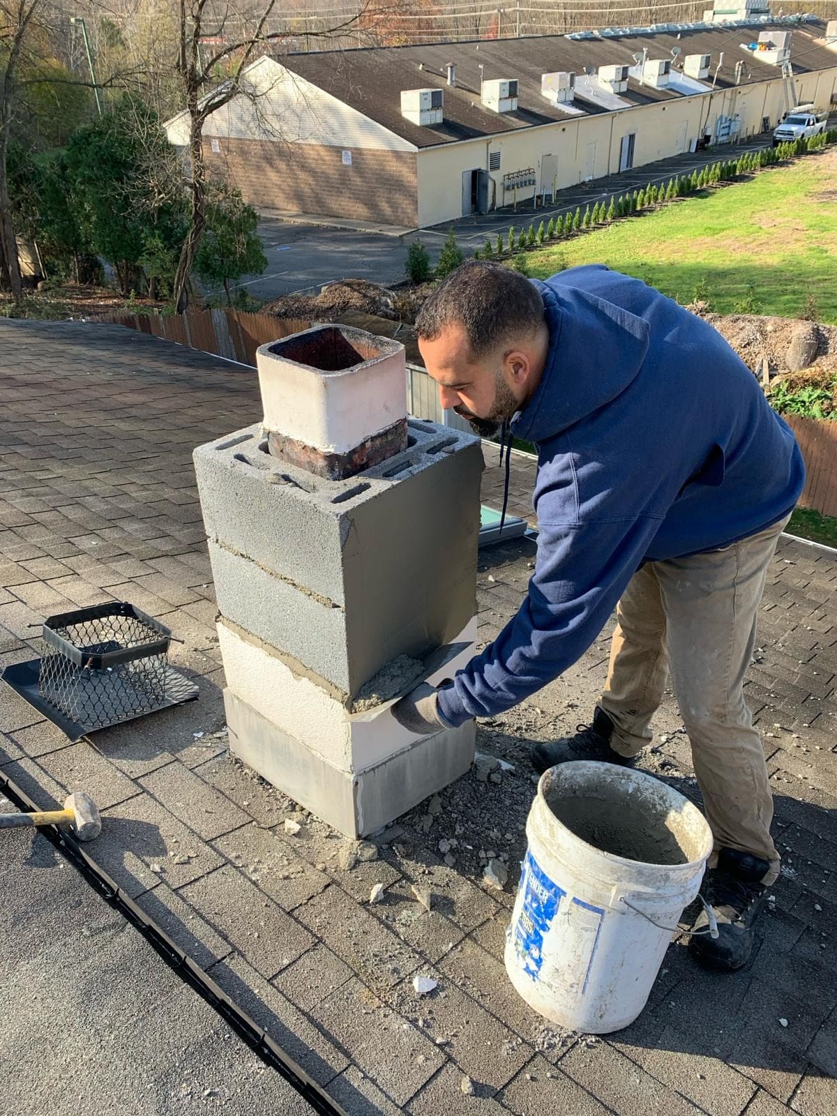 Mason building a new block chimney with a clay flue