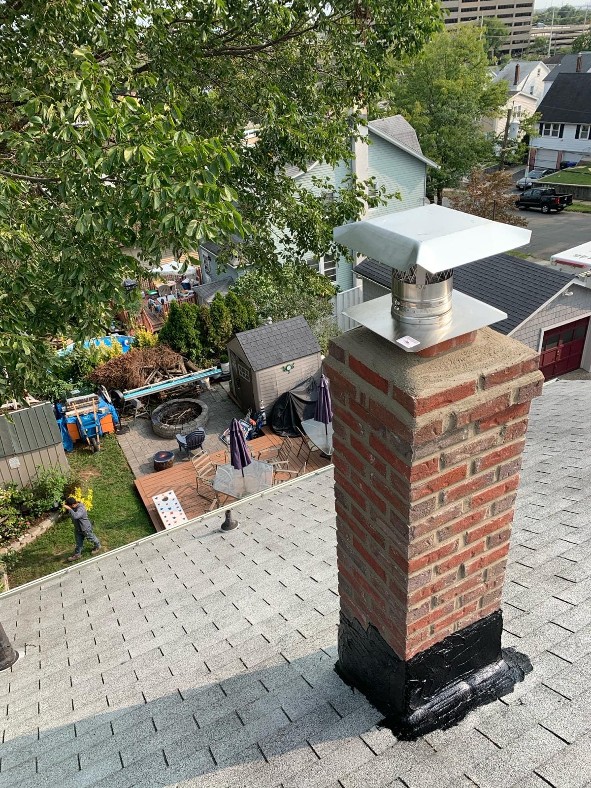Rebuilt brick chimney with a new sealed crown, stainless steel cap and fresh flashing on a shingle roof
